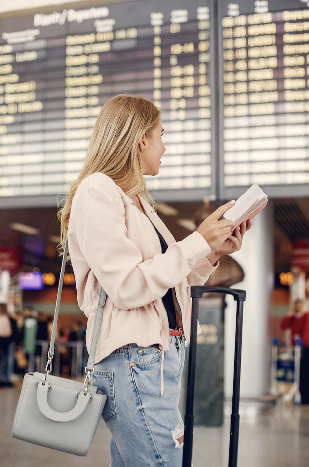 Kvinna på flygplats kollar boardingkort