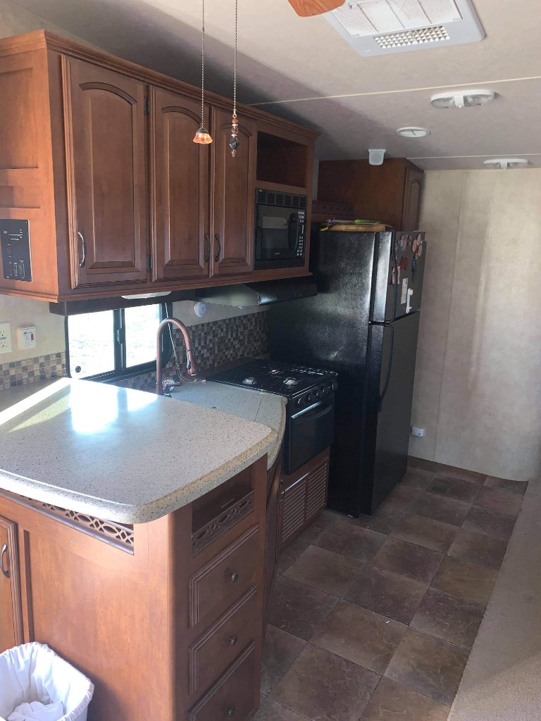 Wildwood full kitchen with dark wood cabinets and island