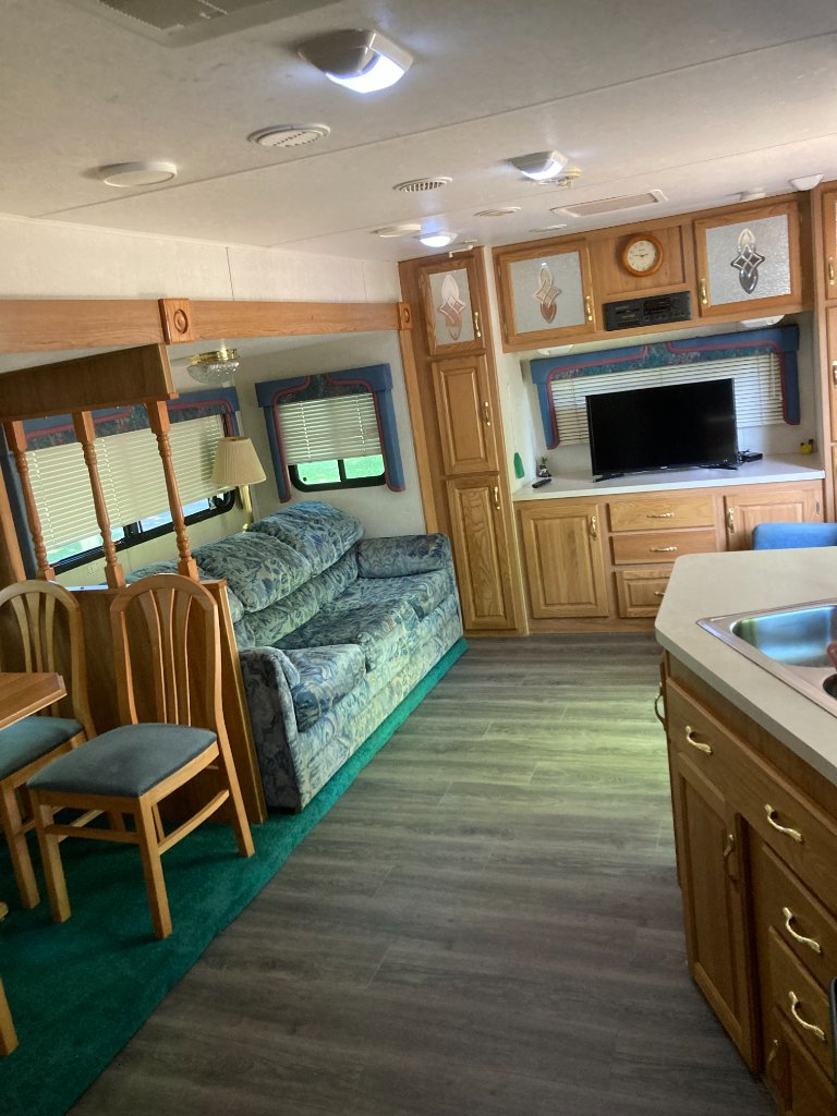 Coachmen interior living area with sofa and entertainment center