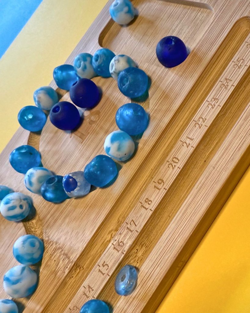 Blue beads arranged on bamboo bead board