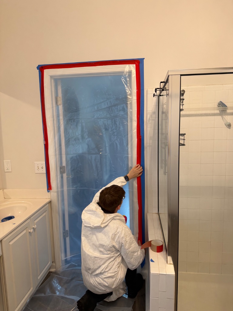 Asbestos containment barrier installation in bathroom