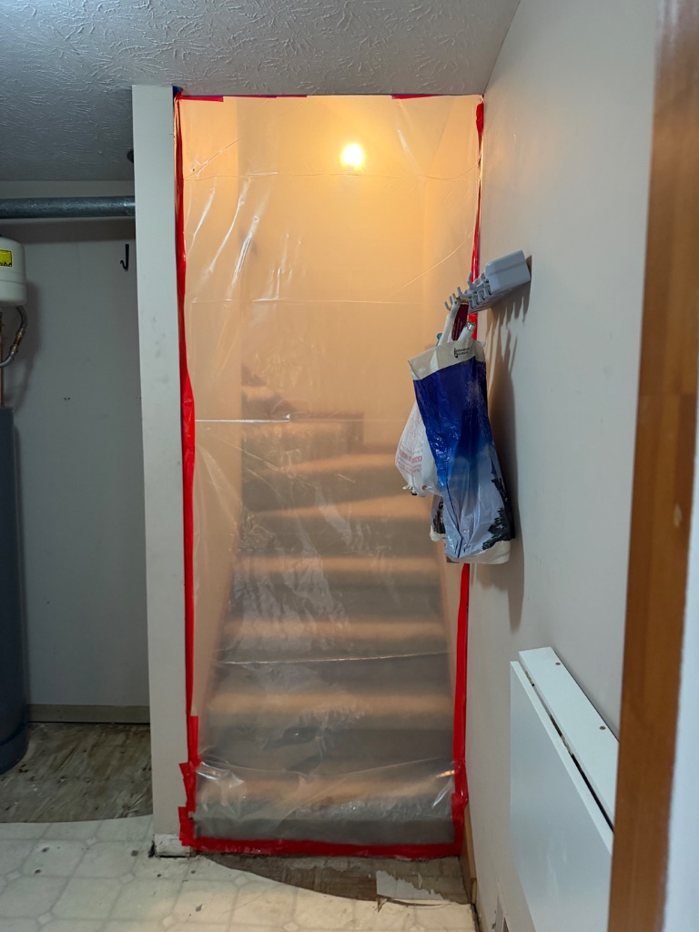 Asbestos containment barrier — doorway sealed with polyethylene
