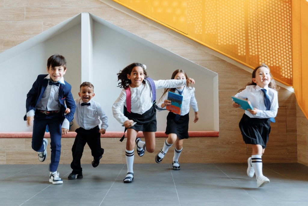 Happy children running in school uniforms