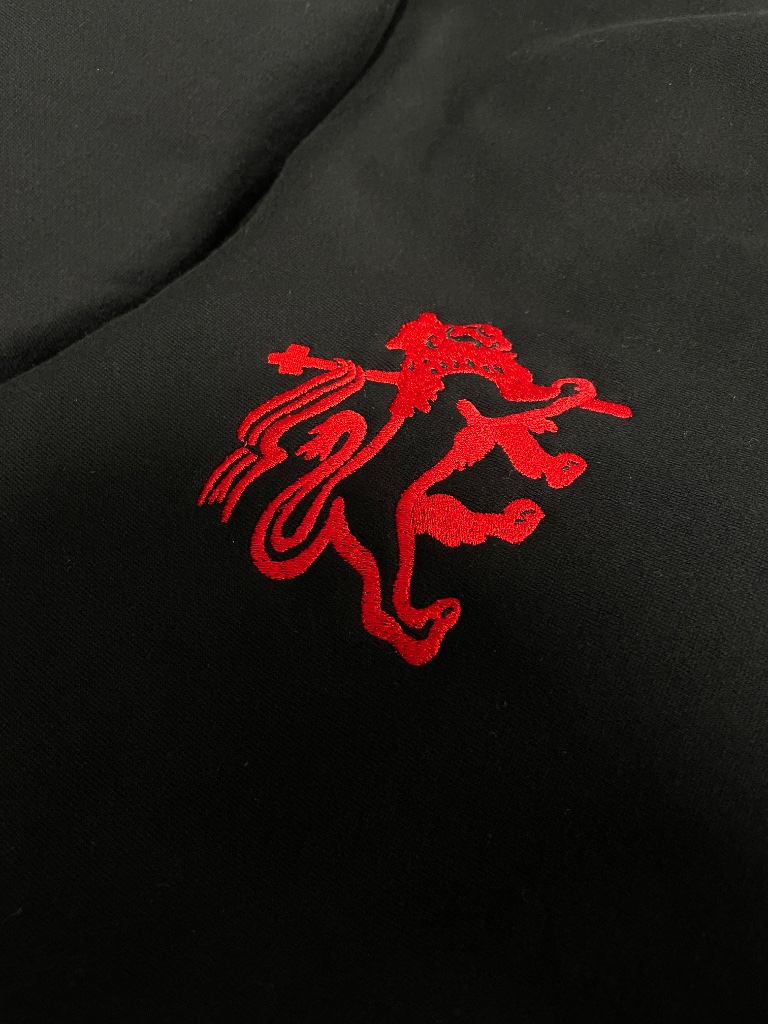 Close-up of custom workwear embroidery stitched onto a black garment