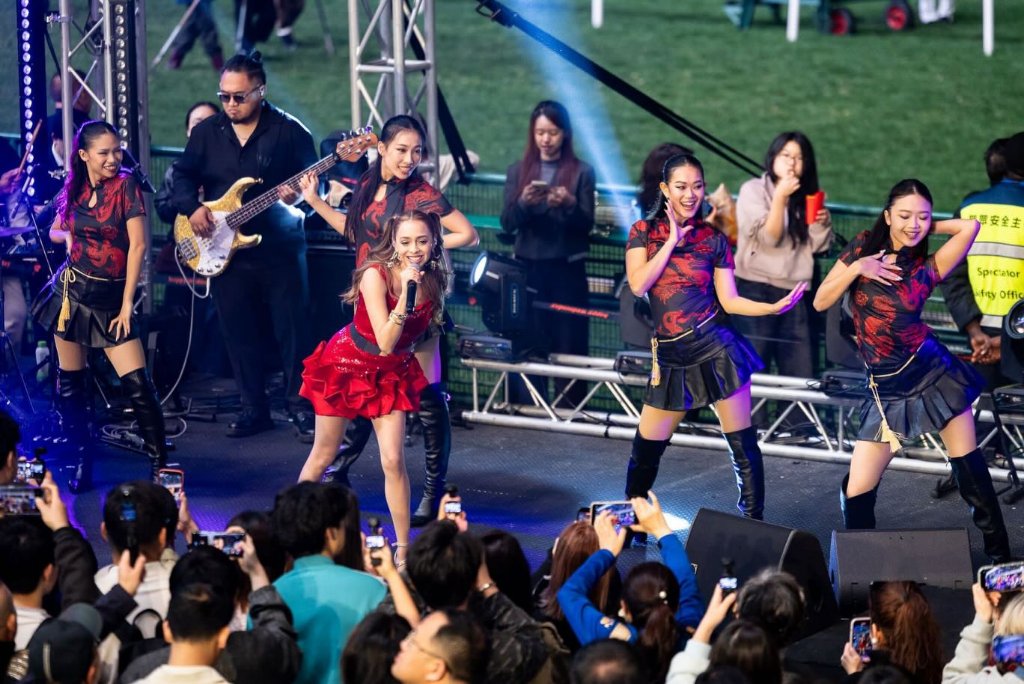 Artist performing with backing band and dancers on the main stage