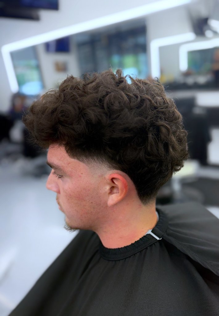 Curly hair with low fade at Galindo's Barbershop