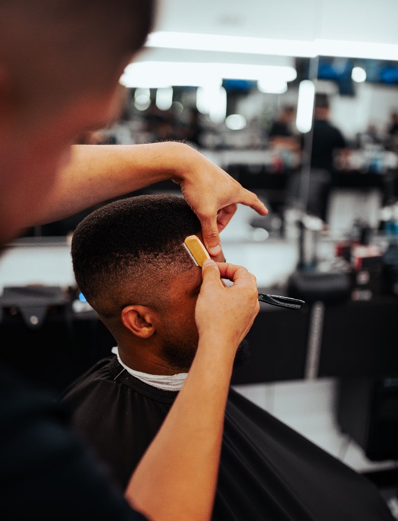 Barber working on client at Galindo's Barbershop
