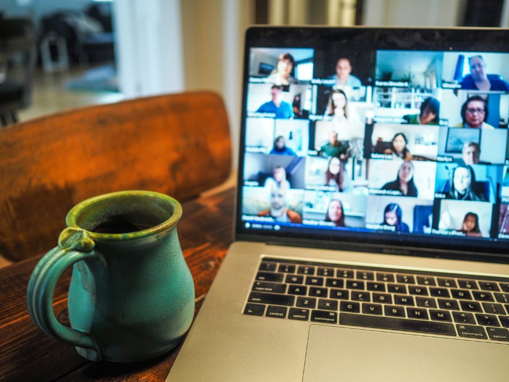 Laptop showing virtual meeting with coffee mug