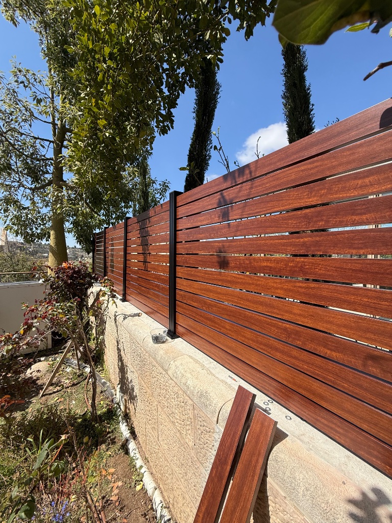 התקנת גדר אלומיניום שילוב של עמודים שחורים עם שלבים בצבע דמוי עץ - חיים פרויקטים ירושלים