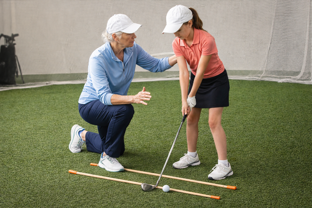 Golf instructor teaching alignment with alignment sticks