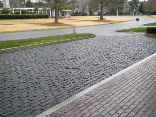 Granite cobblestone curb and brick paver walkway installation at commercial property