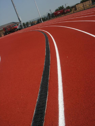 Trench drain system installed at running track and field boundary