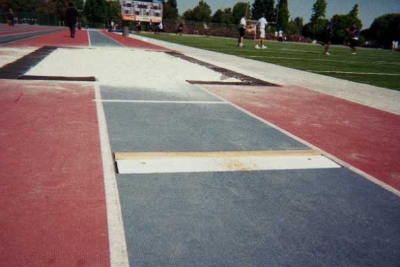 Long jump takeoff board with runway approach at track facility