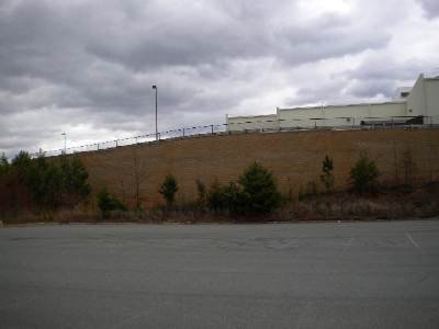 Interlocking concrete block retaining wall at commercial facility with native vegetation