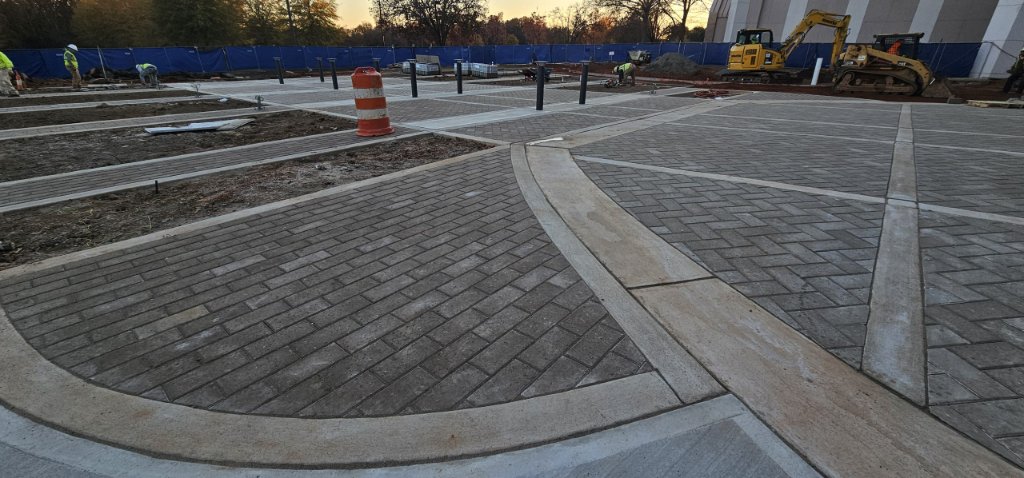 Commercial paver installation with heavy equipment compaction and base preparation