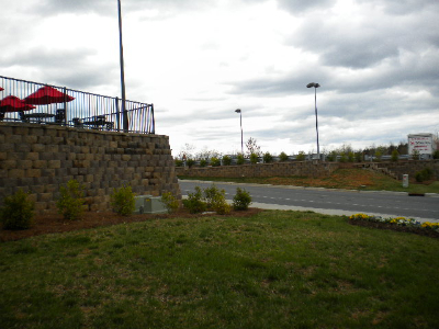 Multi-tiered commercial retaining wall with outdoor patio and dining area