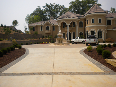 Residential concrete driveway with decorative paver border and accent banding