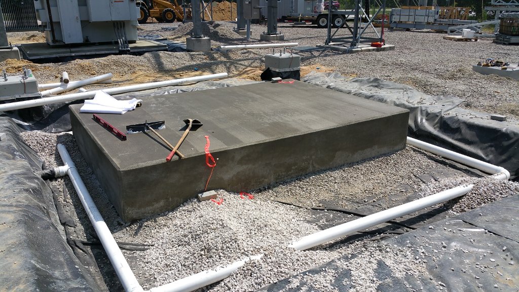 Concrete equipment foundation pad at electrical substation with conduit routing