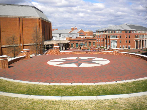 Brick paver plaza featuring decorative star motif with red brick border walls