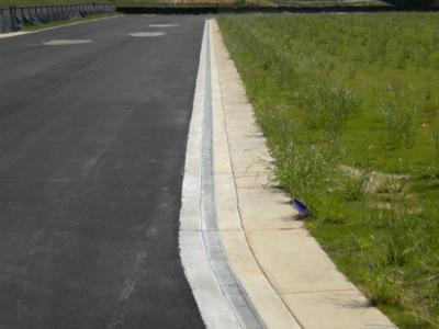 Completed running track with trench drain at turf field transition
