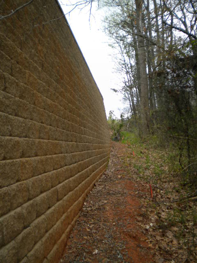 Curved segmental retaining wall along pedestrian walkway with landscaping