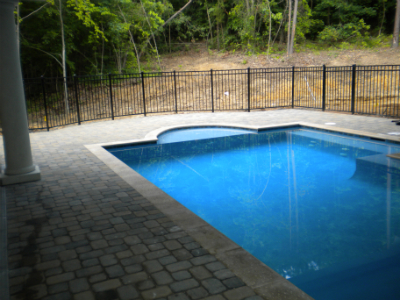 Residential paver patio with stone fire pit and outdoor living space