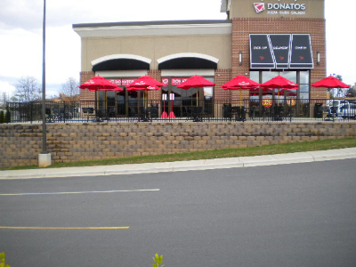 Commercial retaining wall with stone cap and restaurant patio integration