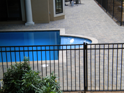 Residential swimming pool deck with interlocking concrete pavers and coping