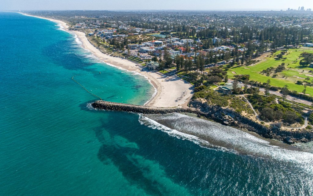 Aerial view of Perth beachside suburb with turquoise Indian Ocean coastline and residential properties — typical Western Australia Airbnb location requiring AS 3745 compliant fire evacuation diagrams