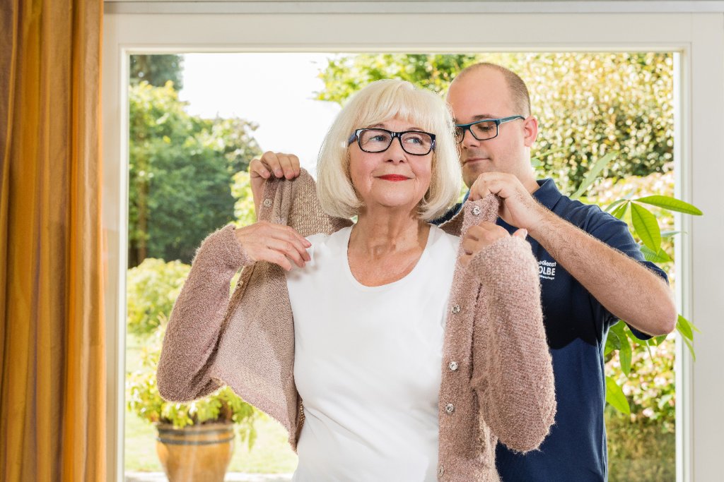 Pflegedienst Kolbe - Pflegekraft hilft Seniorin beim Anziehen der Jacke - Grundpflege Mönchengladbach
