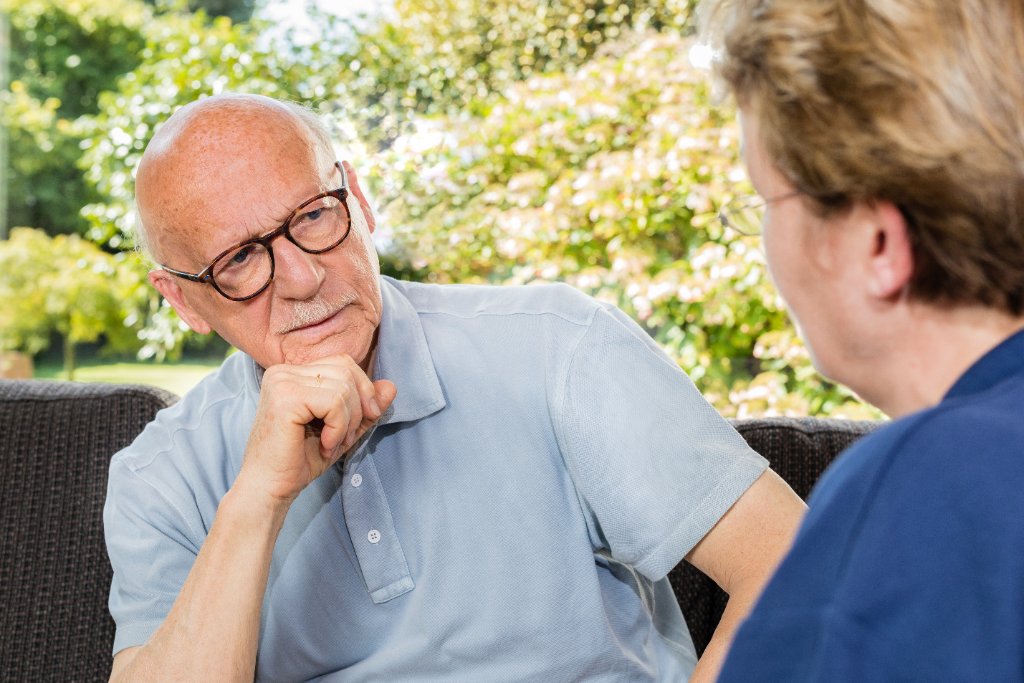 Beratungsgespräch häusliche Pflege - Pflegekraft berät Senior im Garten - Pflegedienst Kolbe
