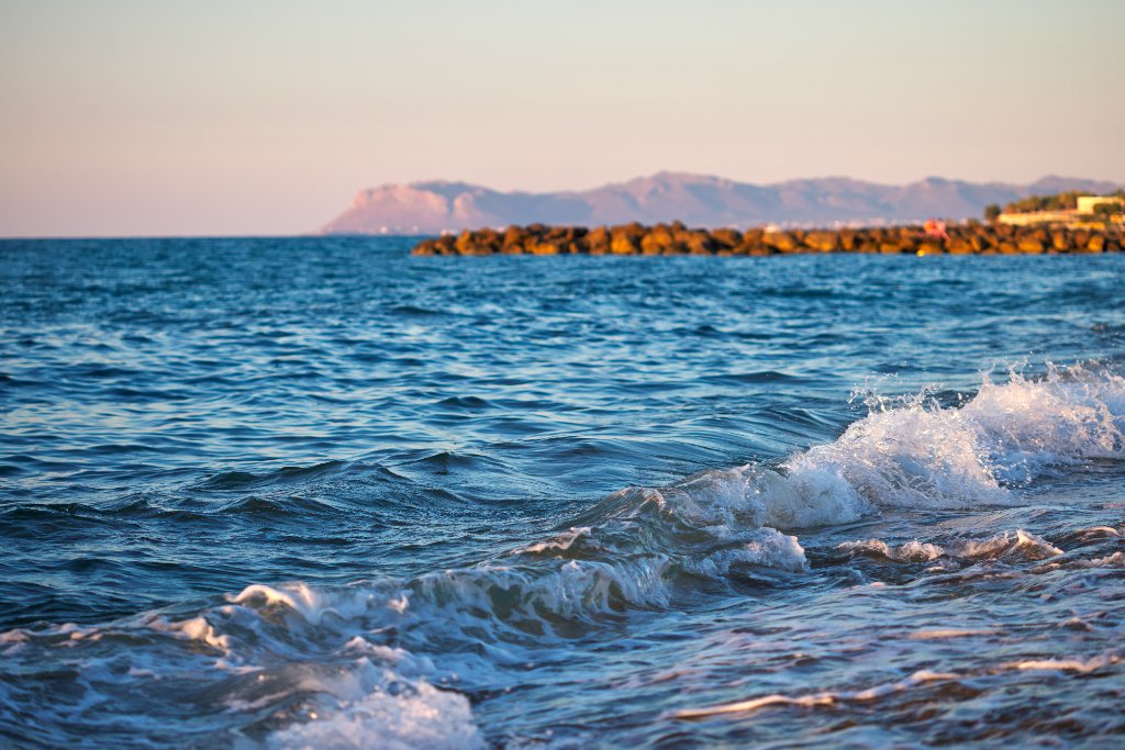 Ocean waves at sunset symbolizing flow and transformation in healing journey
