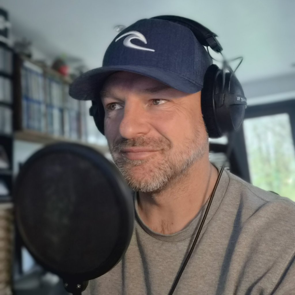 Rosko Lewis — British voice over artist recording at the microphone in his professional Cornwall home studio