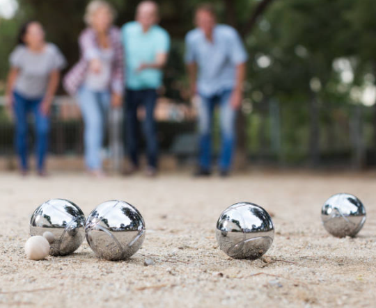 Pétanque metal boules and wooden jack on playing surface