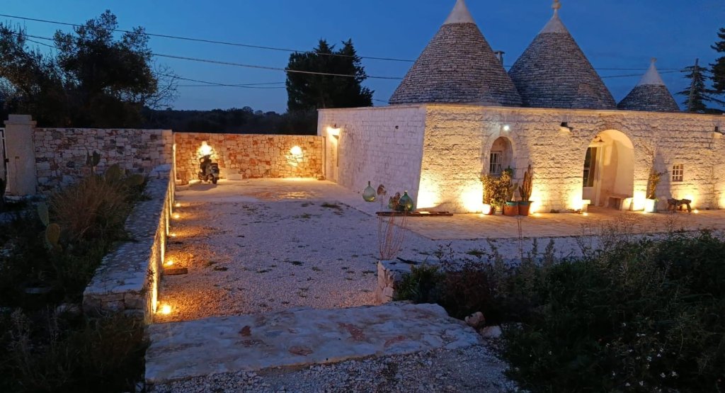 Illuminated trulli at dusk