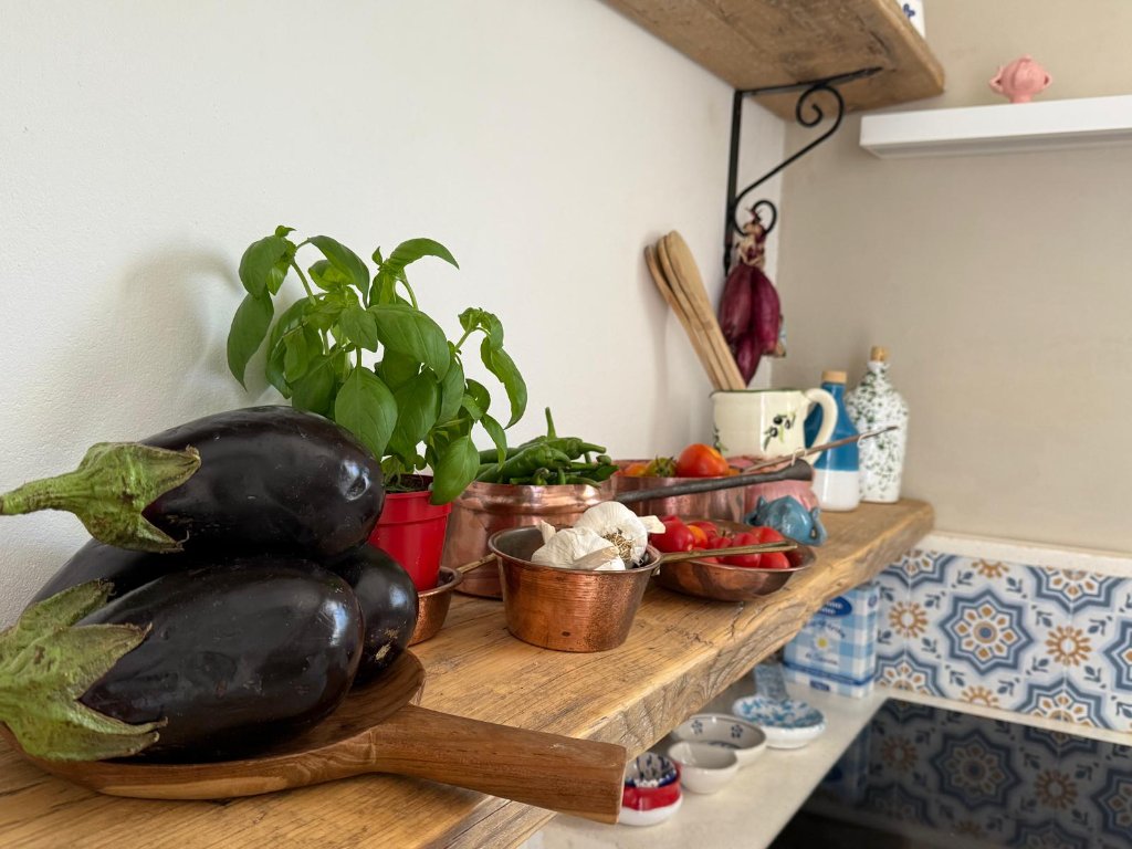 Rustic kitchen counter with fresh vegetables and copper bowls