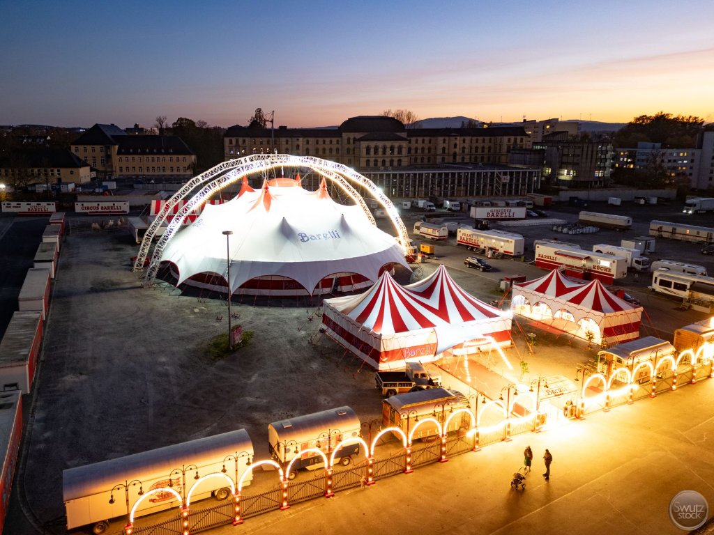 Zeltpalast illuminiert bei Sonnenuntergang mit rot-weißem Dach