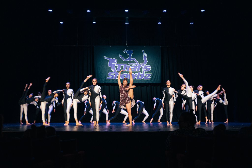Dancers mid routine under stage lights