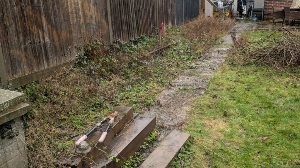 Before: weed-covered Basingstoke garden path and borders weeded and jet washed clean