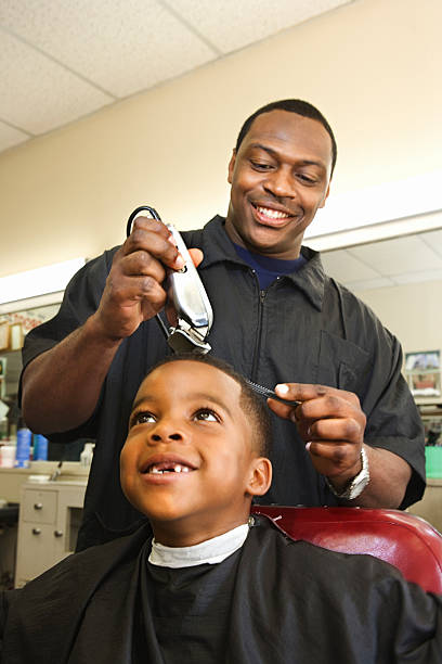 Barber providing a free haircut to a young boy in Southwest Atlanta as part of Talk Thairapy's community care initiative