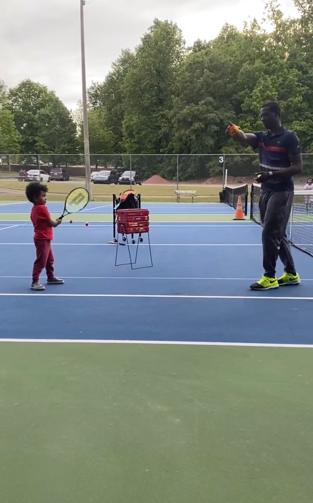 Coach Tee teaching beginner tennis fundamentals to young player in Roswell, GA