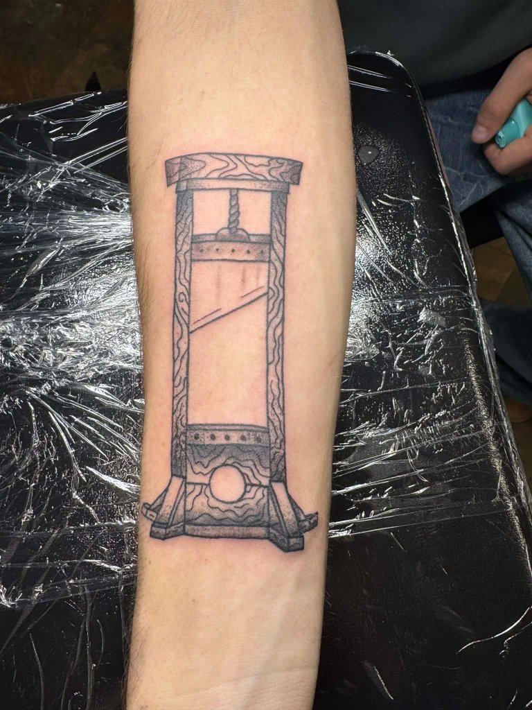 Guillotine fine line tattoo