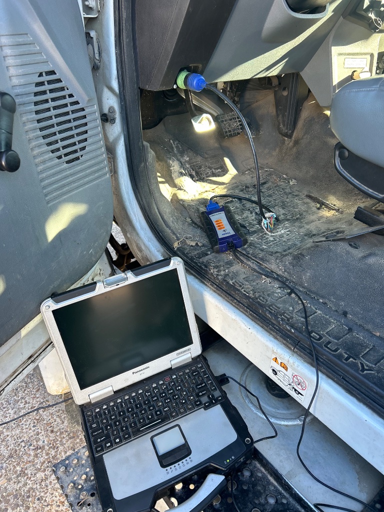 CRANETEC technician running diagnostic scan on bucket truck control system — preventive maintenance DFW