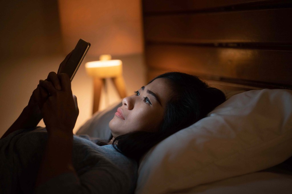 Person in bed with phone glowing at night