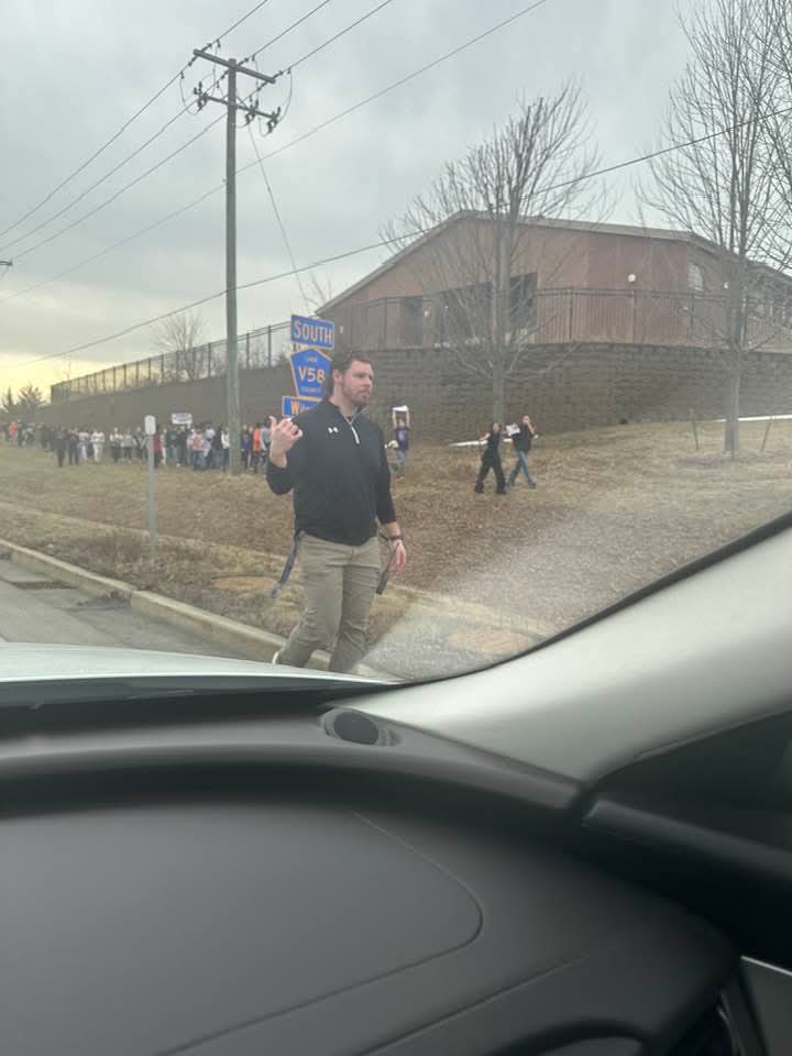 Staff member near roadside during student walkout