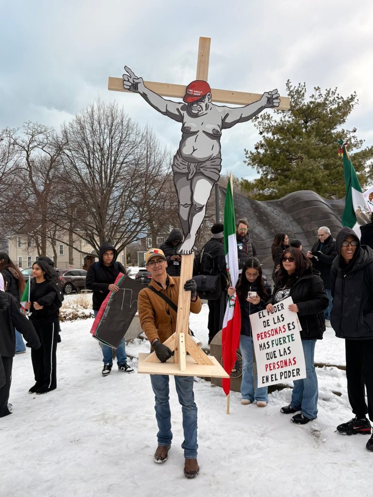 Protester holds a large crucifix-style display in a public area