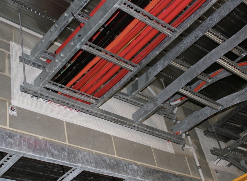 Professional fire stopping installation with intumescent materials sealing building penetrations