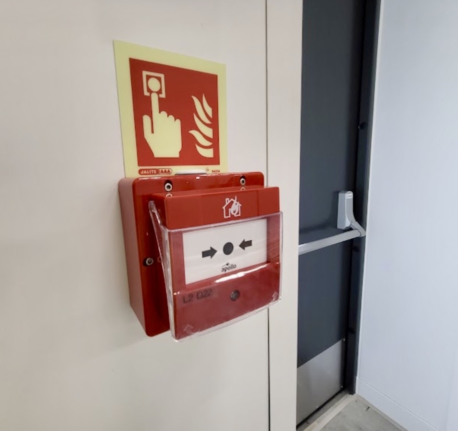 Fire alarm manual call point mounted on white wall