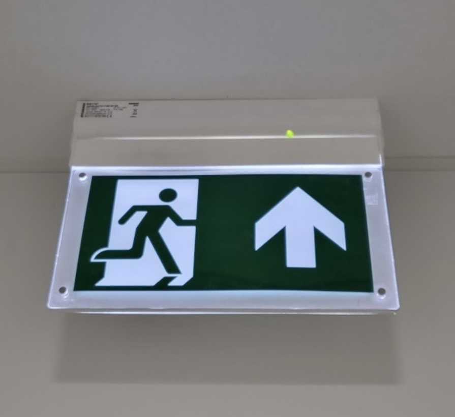 Emergency exit lighting system illuminated in commercial hallway