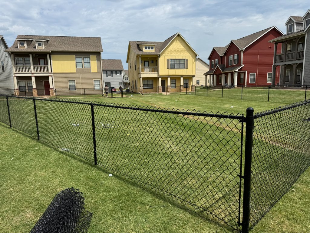 Black vinyl-coated chainlink fence installation in Stillwater Oklahoma